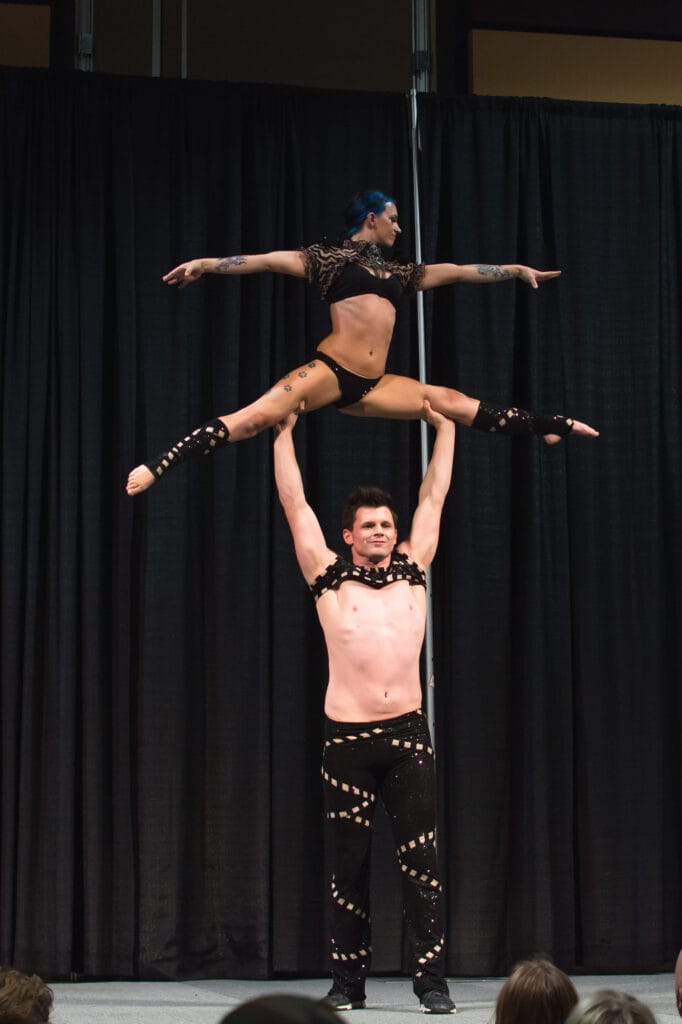 Acrobats performing balance routine on stage.
