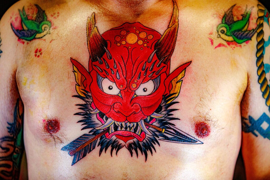 Colorful demon tattoo on man's chest