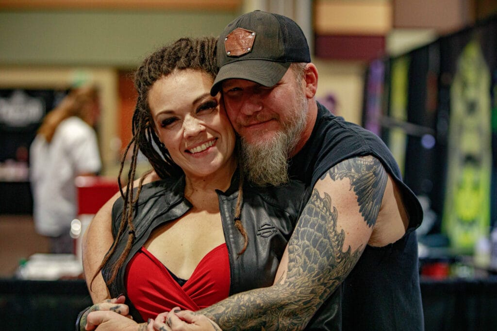 Smiling couple embracing at tattoo convention