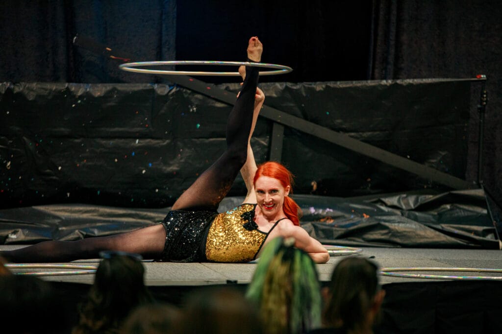 Performer balancing hula hoops on stage.
