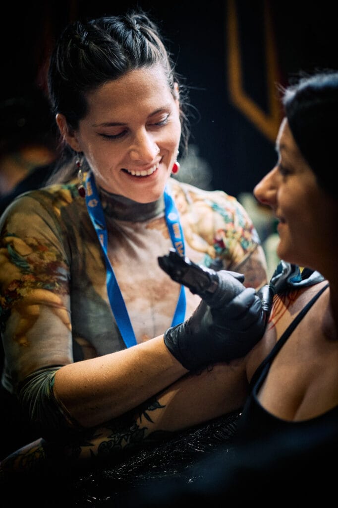 Tattoo artist working on a client at convention.