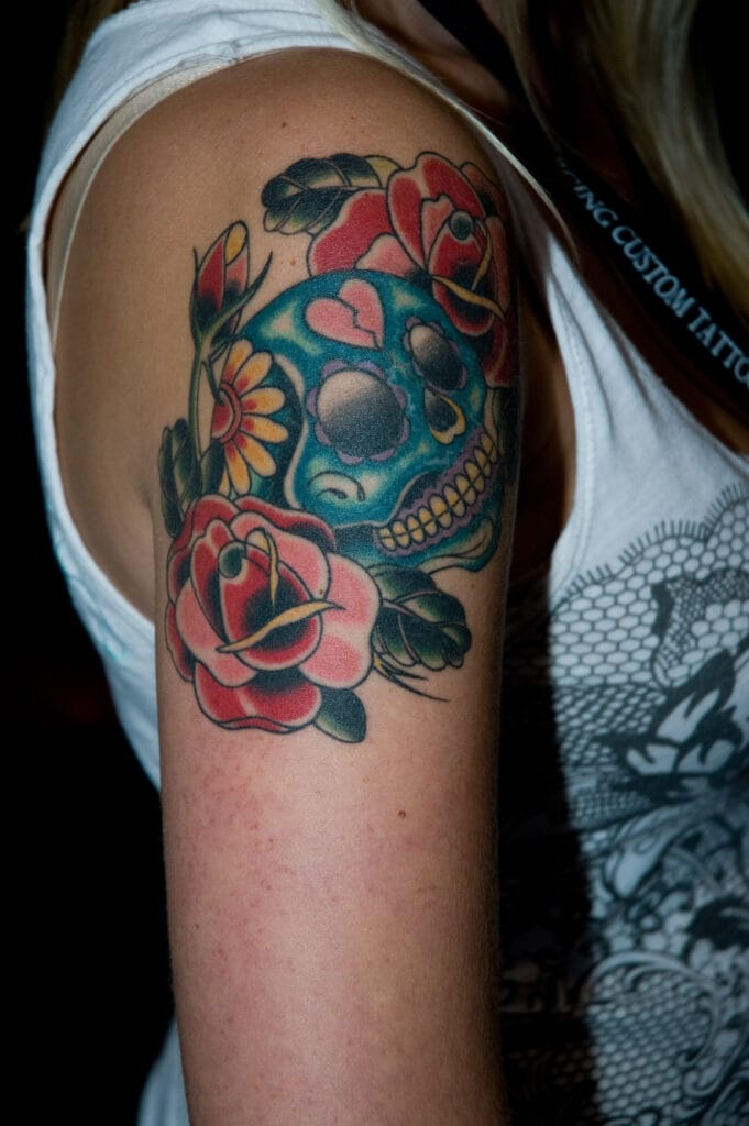 Colorful skull and roses tattoo on arm