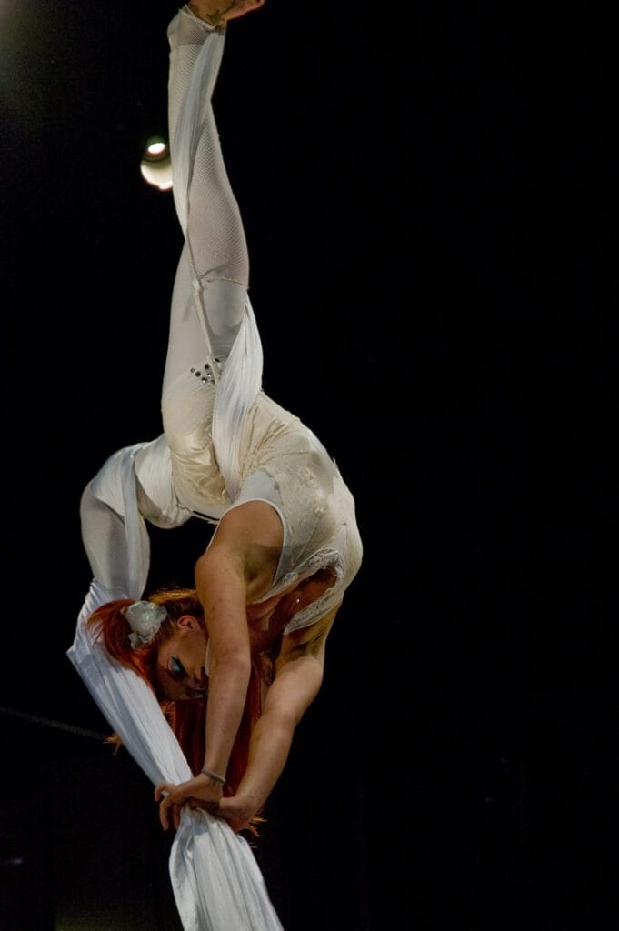 Aerial performer doing silk acrobatics on stage