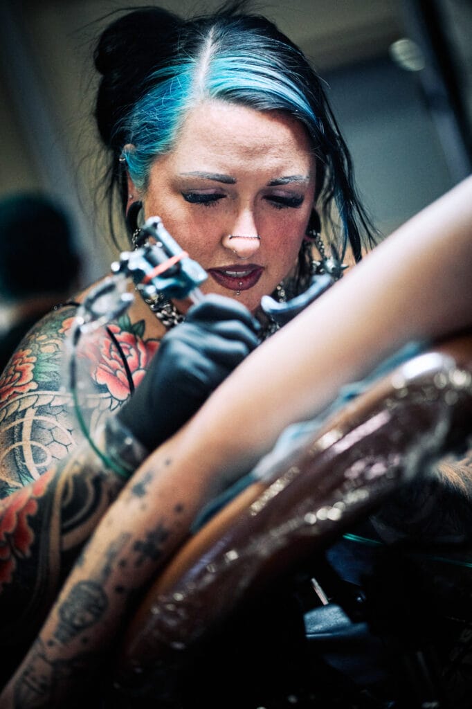 Tattoo artist focused on intricate design creation.