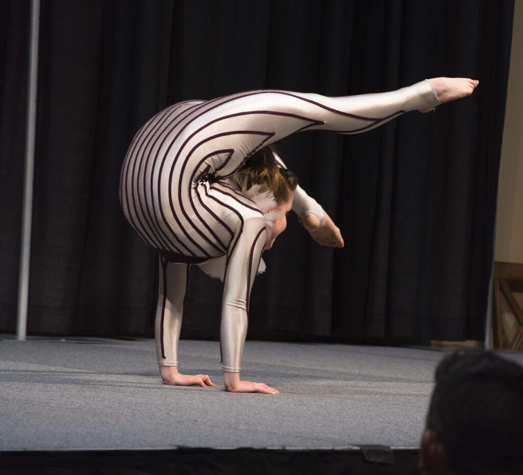 Contortionist performing a backbend on stage.