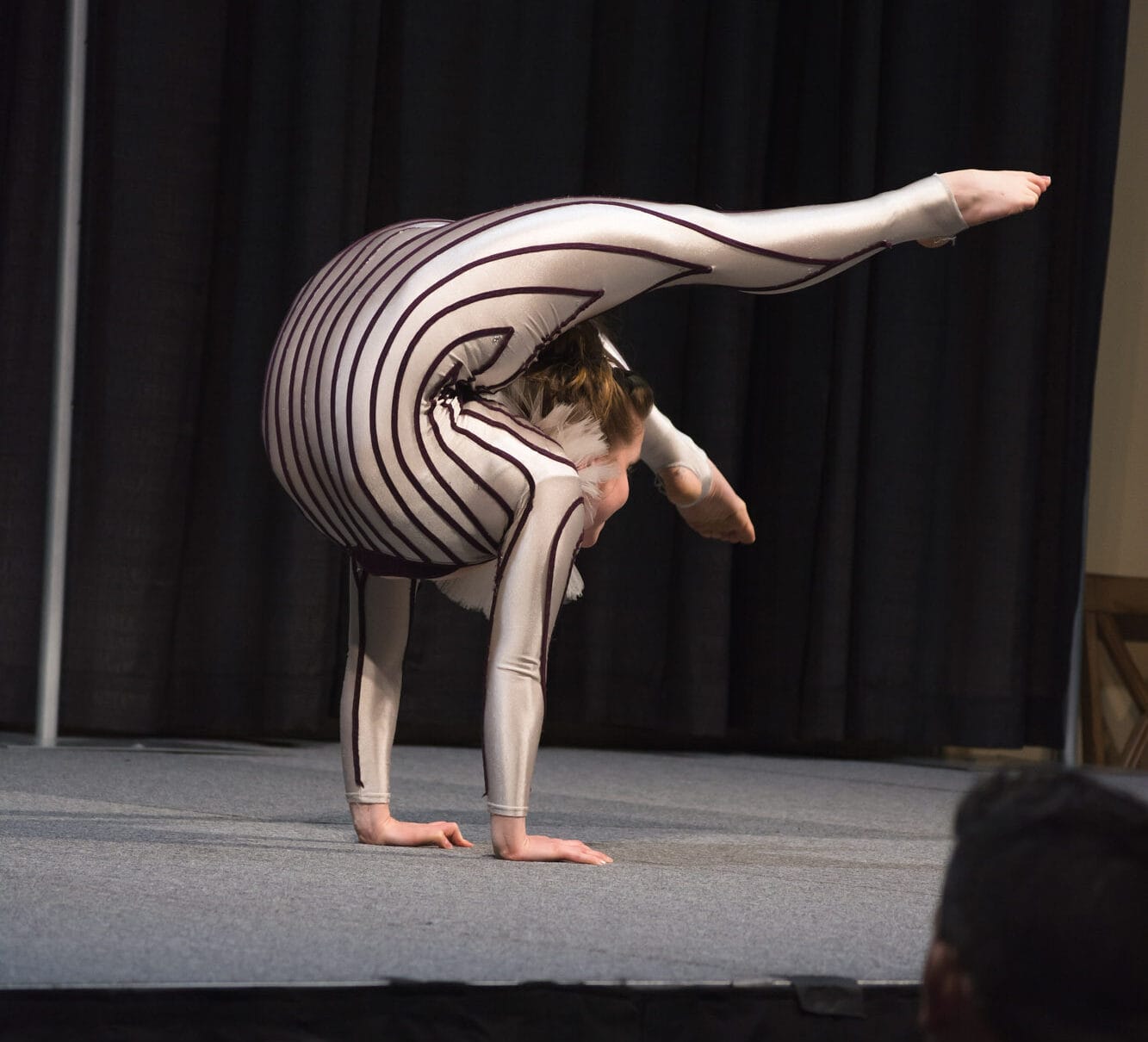 Contortionist performing a backbend on stage.