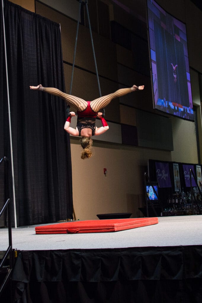 Aerial performer upside down on stage
