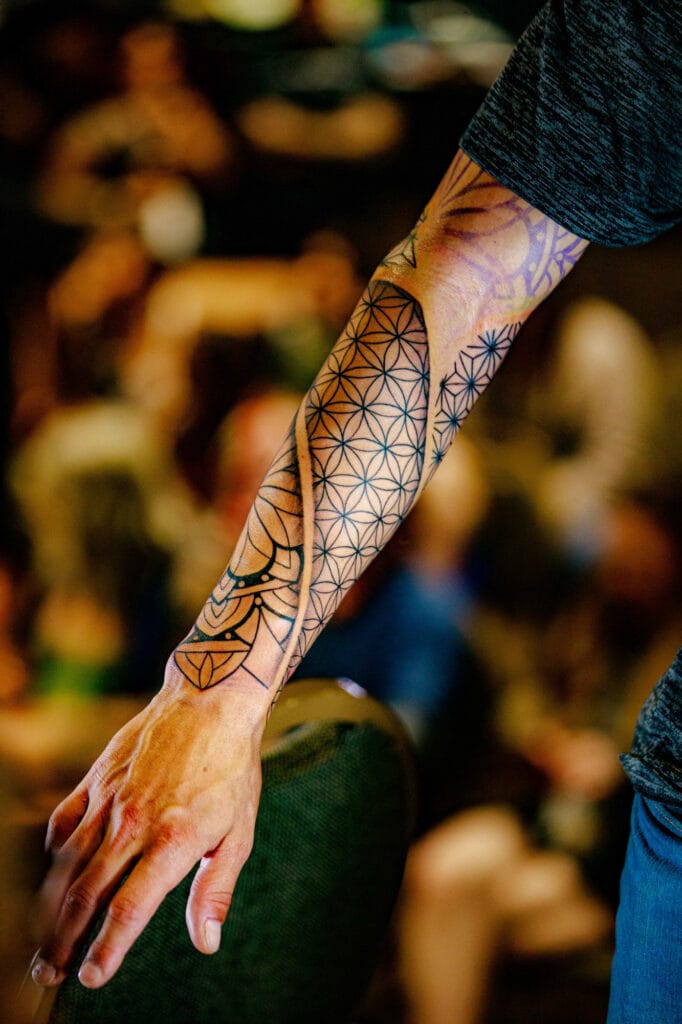 Arm with intricate geometric tattoo design.