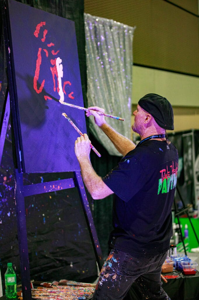 Artist painting on large canvas at event