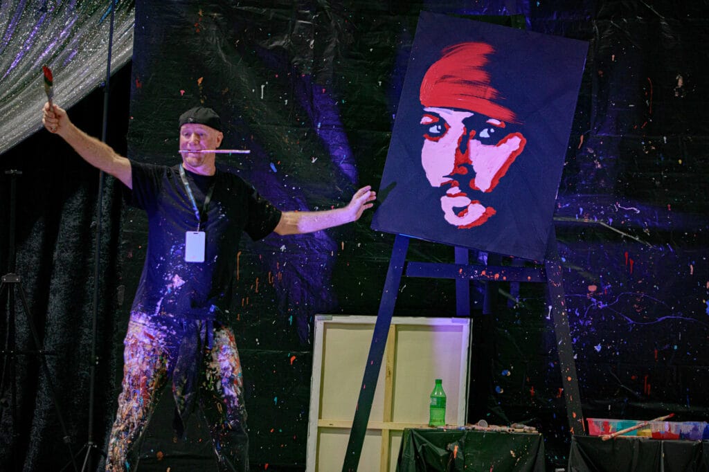 Performance artist painting creatively on stage