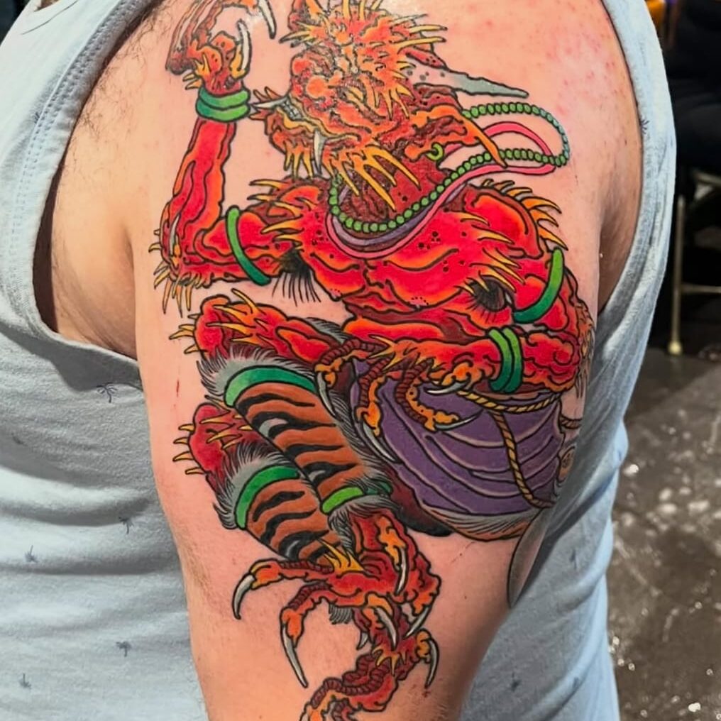 Colorful mythical creature tattoo on upper arm